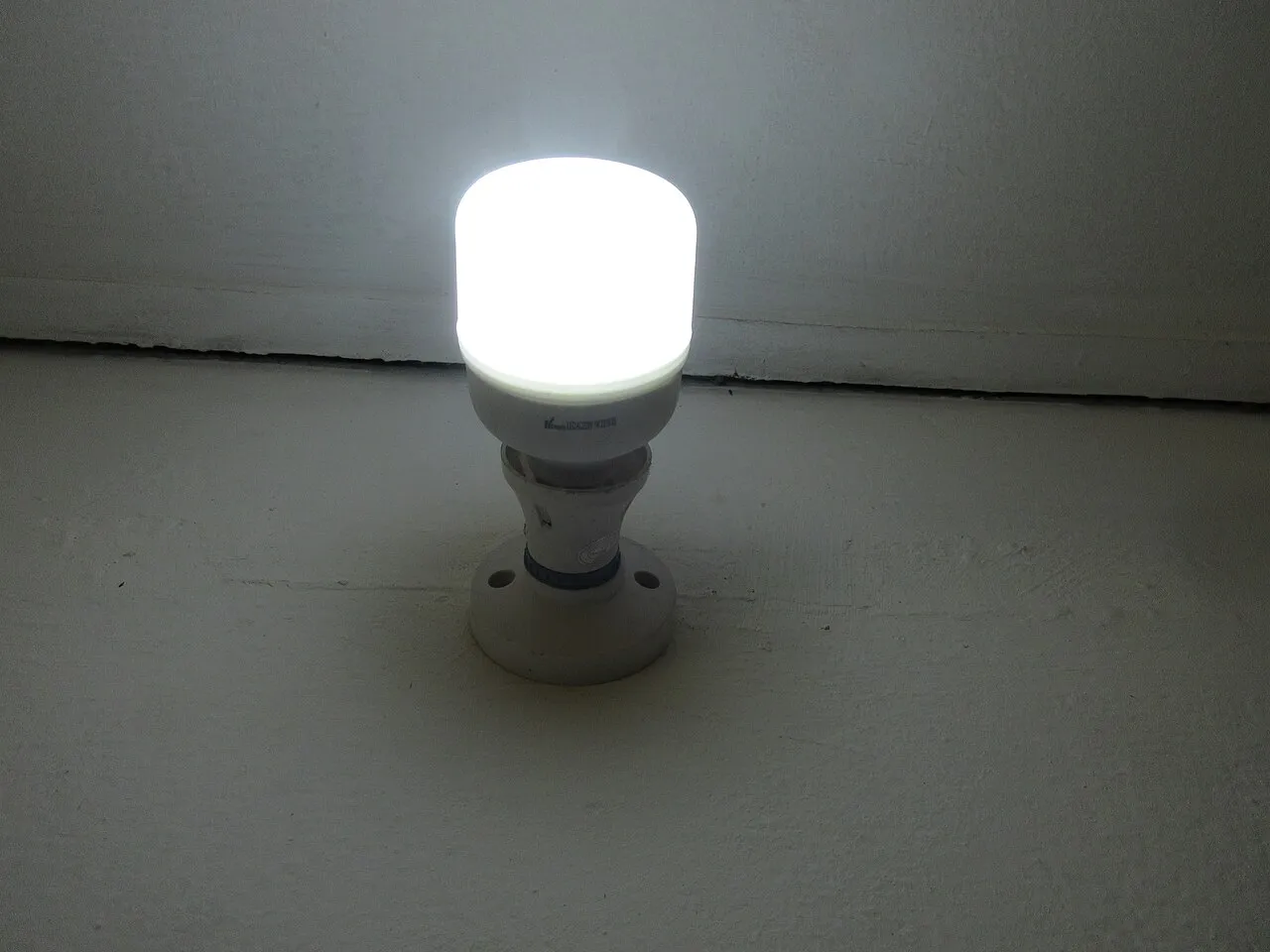 Ampoule LED allumée sur une douille fixée au mur