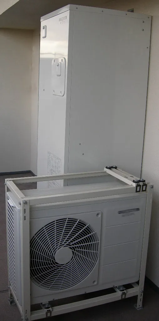Chauffe-eau thermodynamique en deux parties sur un balcon : ballon blanc et unité extérieure à ventilateur