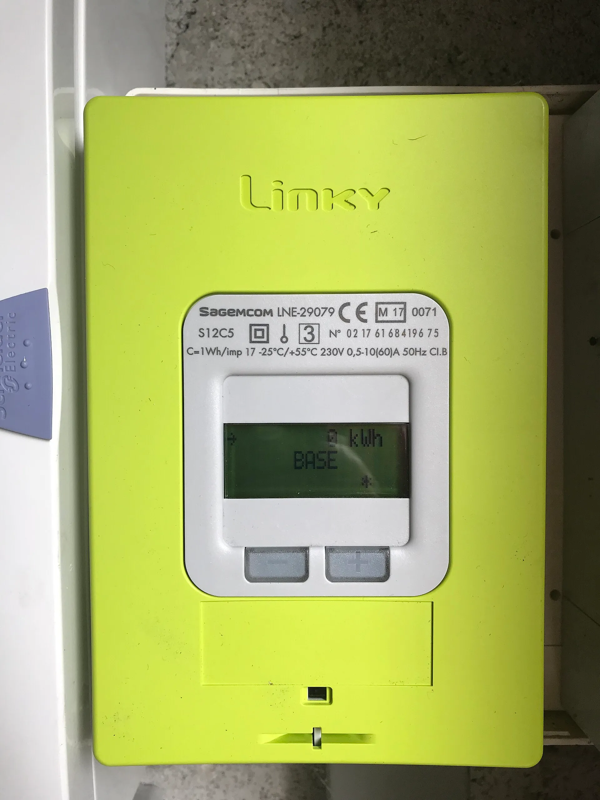 Compteur électrique Linky vert fixé au mur, avec son écran et ses deux boutons