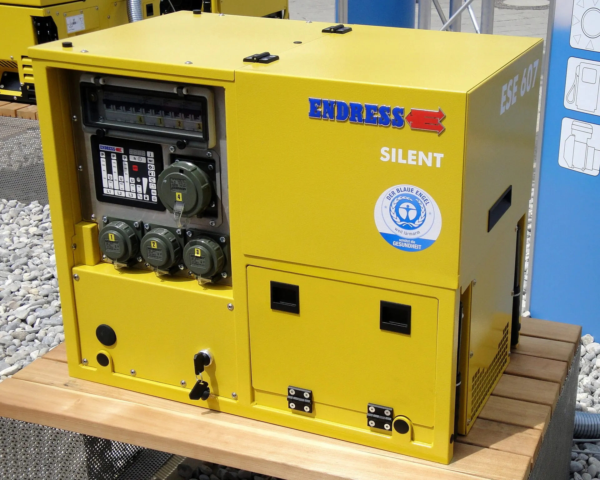 Groupe électrogène insonorisé jaune, enfermé dans un capot, avec ses prises en façade