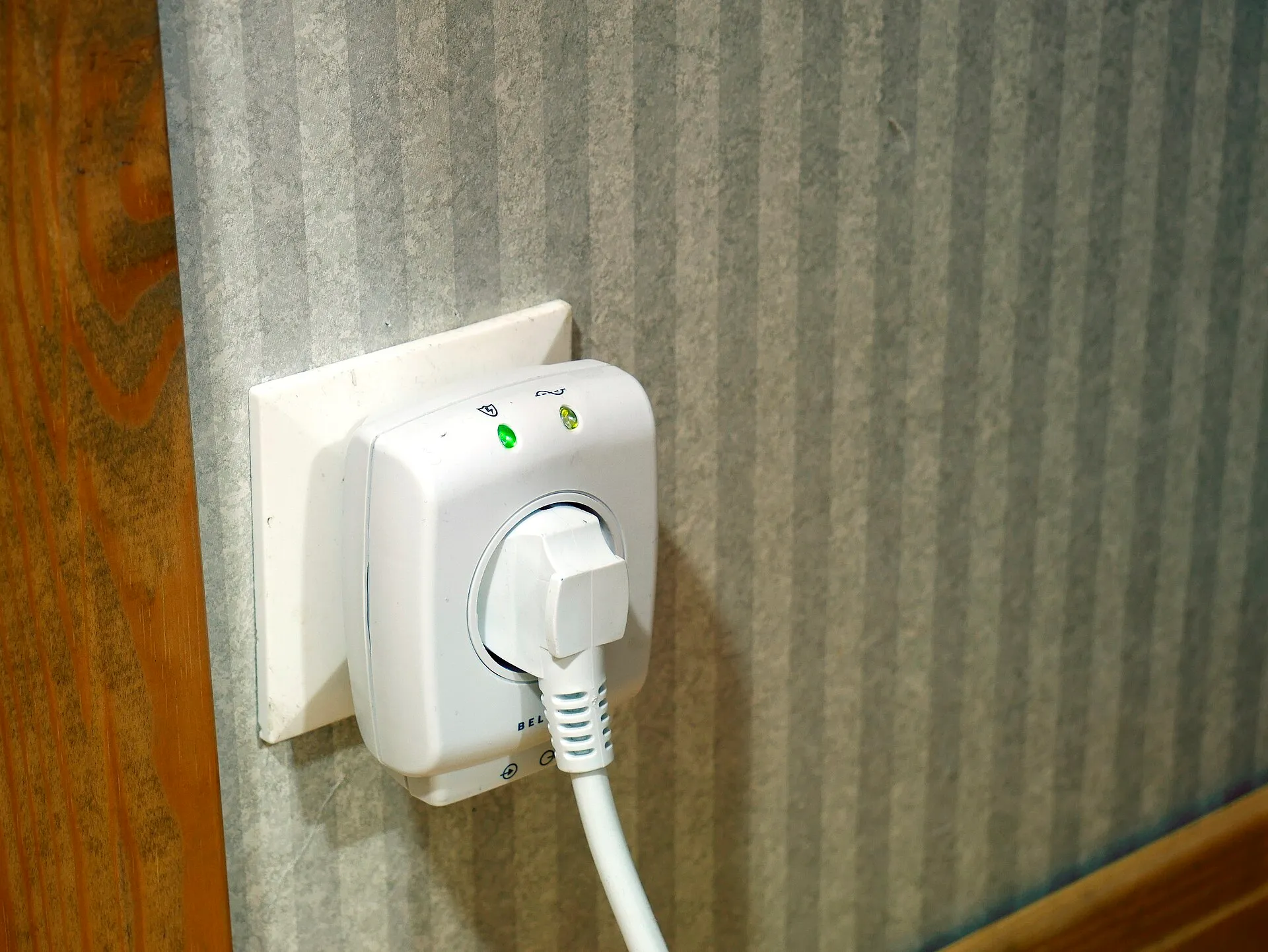 Adaptateur parafoudre branché sur une prise murale, avec un câble qui y est raccordé