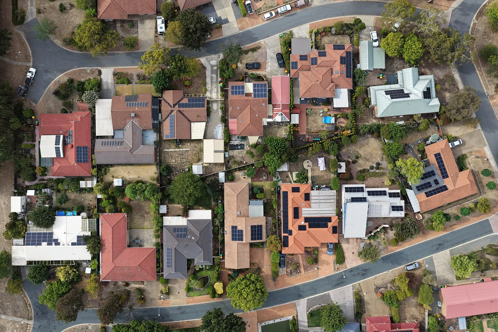 Vue aérienne d'un quartier pavillonnaire où de nombreux toits portent des panneaux solaires